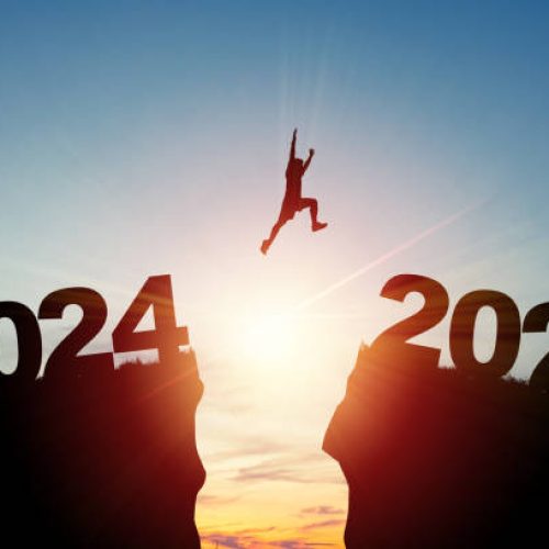 Welcome merry Christmas and happy new year in 2025,Silhouette Man jumping from 2024 cliff to 2025 cliff with cloud sky and sunlight.